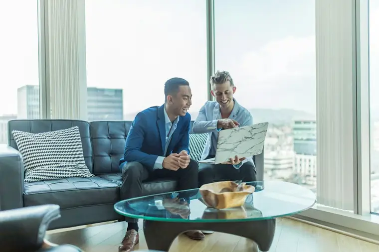 Two advisors in conversation on a sofa