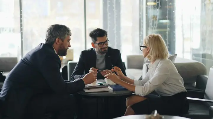 Advisors and a client in a planning meeting around a table