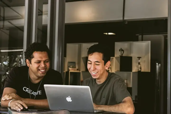 Two business founders smiling at a laptop